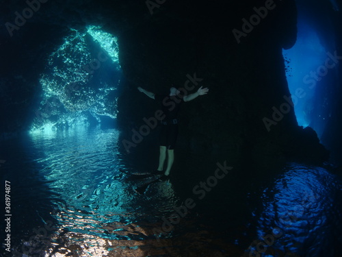 free diver  underwater sun beams and sun rays freediver apnea man exploring underwater rocks 