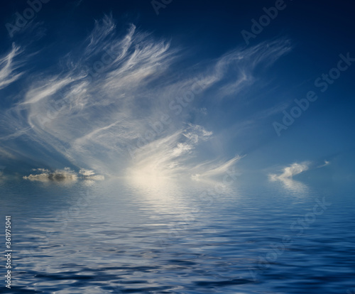 Dramatic sky with clouds reflected in water.