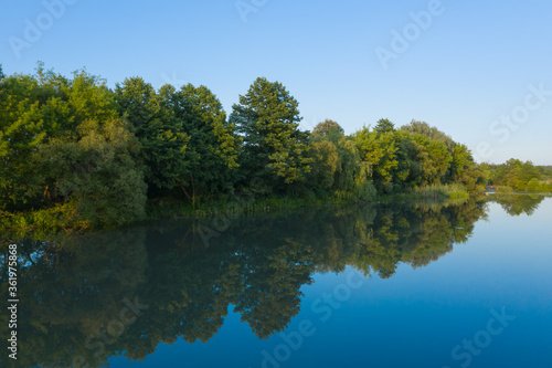 River and reflection of trees in water, evening landscape of nature, aerial view in summer