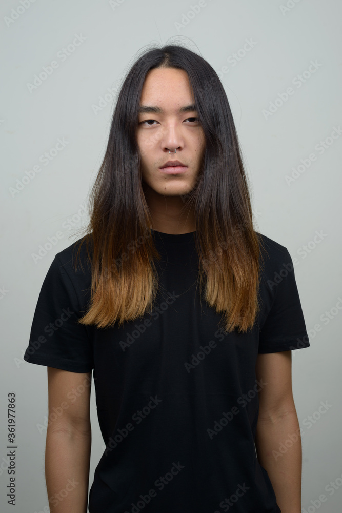 Young Asian man with long hair looking at camera Young Asian man with long hair looking at camera