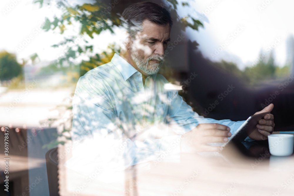 Happy mature businessman having coffee break in cafe. Happy mature businessman having coffee break in cafe.