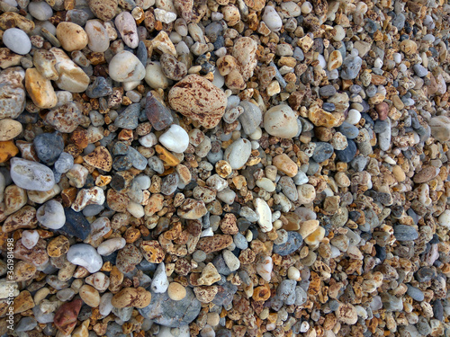 Round multi-colored pebbles on the seashore. Greece.