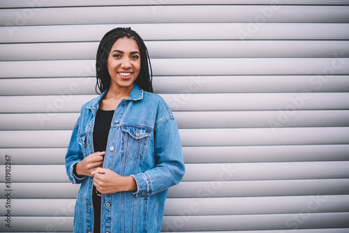 Photos Half length portrait of cheerful dark skinned female student standing near copy