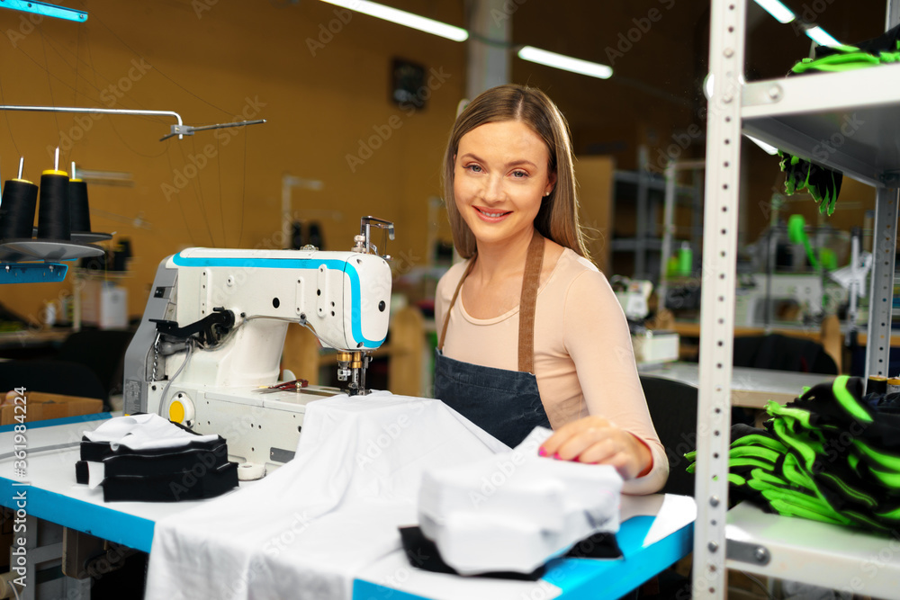 Beautiful female seamstress working with fabric at her workplace Beautiful female seamstress working with fabric at her workplace
