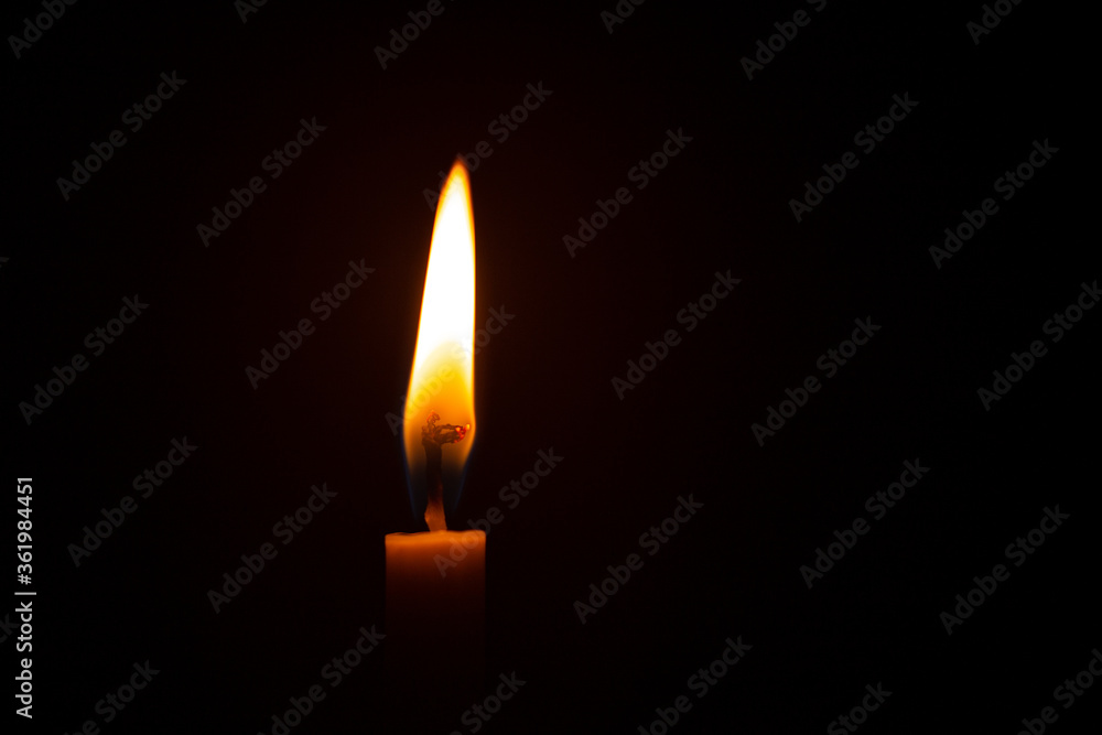 Close up single candle light and flame on black background Close up single candle light and flame on black background