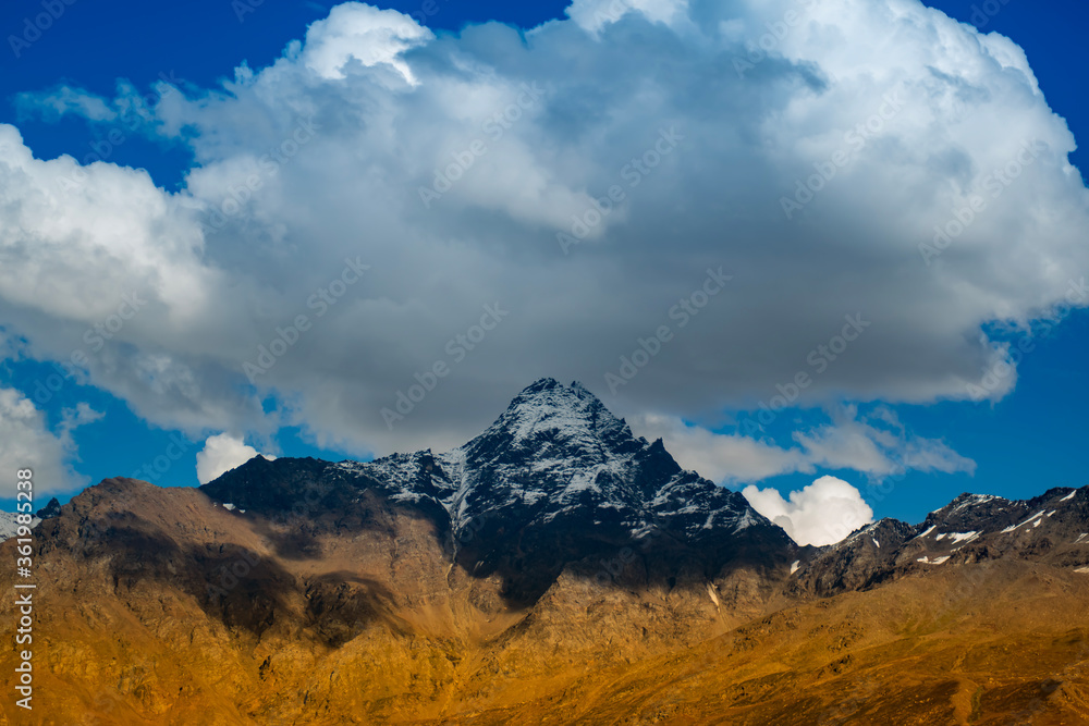 clouds over the mountains like  a hat