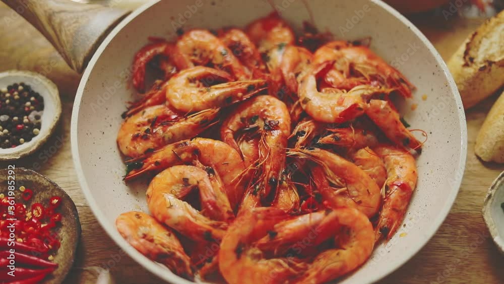 Traditional fried tiger prawn with garlic bread as top view served in a white frying pan Traditional fried tiger prawn with garlic bread as top view served in a white frying pan