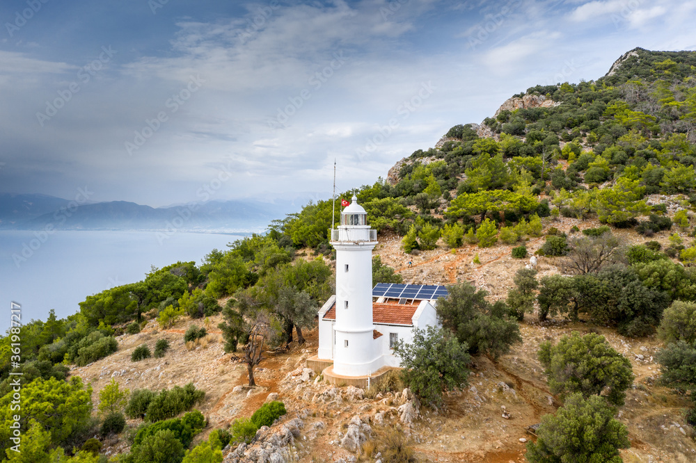 Obraz premium Gelidonya Lighthouse at cape in Mediterranean sea. Lighthouse and three Islands on Lycian Way in. Karaoz, Antalya, TURKEY