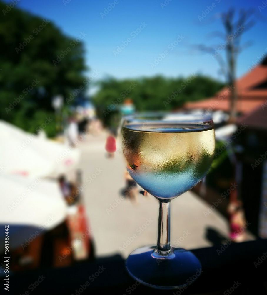Obraz premium Summertime. Relaxing time with a glass of delicious dry white wine.