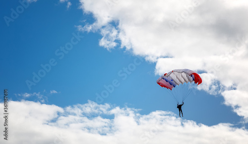 skydiver high in the clouds, blue streak of sky