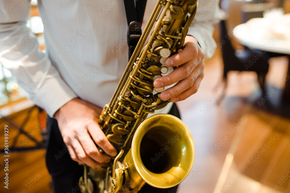 Obraz premium A man plays the saxophone. close-up of hands