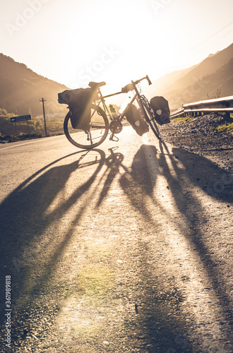 Background image of standing touring bicycle without cyclist on the road with nocars. Cycling in a countryside. Kazkbegi nationalpark. Georgia.2020 photo