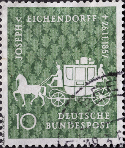 GERMANY - CIRCA 1957: This postage stamp shows a postkutzsche with horse and coachman. Text: Joseph von Eichendorff November 26, 1857. 100th anniversary of death photo