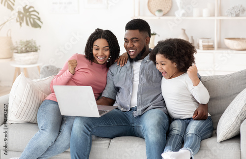 Online Lottery. Excited African American Family Of Three Celebrating Win With Laptop