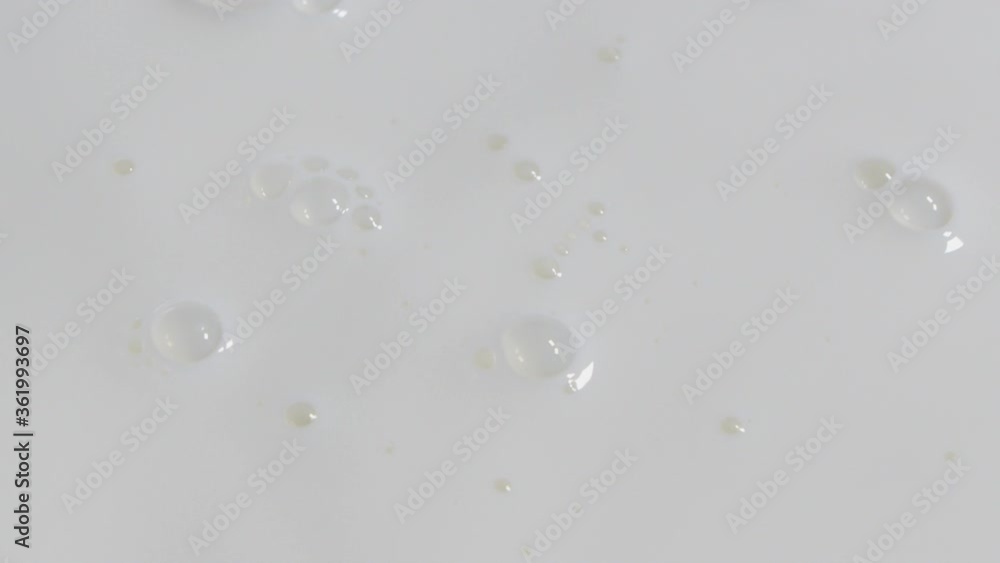 A drop of milk falls into the milk background and leaves behind a white ripple. Drop of Milk Drips and Makes Ripples in the Milk Background. Milk Drop Falls into Milk, Slow Motion. A drop of milk falls into the milk background and leaves behind a white ripple. Drop of Milk Drips and Makes Ripples in the Milk Background. Milk Drop Falls into Milk, Slow Motion.
