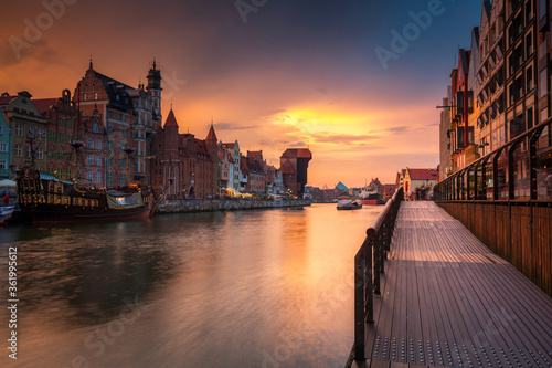 Old town in Gdansk with historical port crane over Motlawa river at rainy sunset, Poland.
