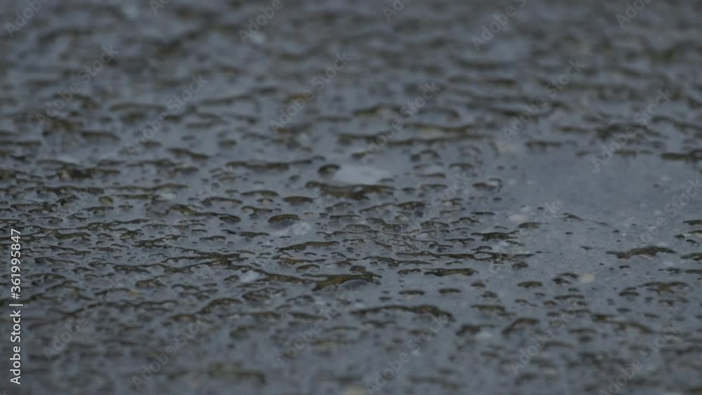 Close up of raindrops on concrete sidewalk, slow motion Close up of raindrops on concrete sidewalk, slow motion