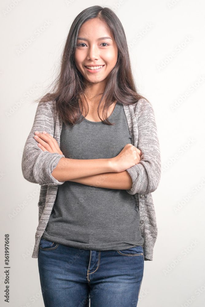 Happy young beautiful Asian teenage girl smiling with arms crossed Happy young beautiful Asian teenage girl smiling with arms crossed