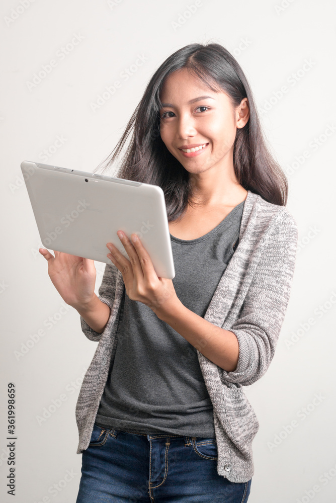 Happy young beautiful Asian teenage girl using digital tablet Happy young beautiful Asian teenage girl using digital tablet
