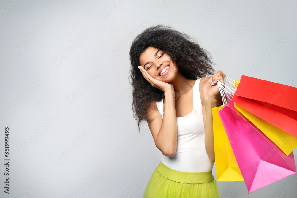 Portrait of a beautiful african woman with bags on grey background Portrait of a beautiful african woman with bags on grey background