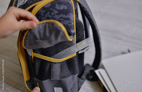  Sanitizer in a school backpack. Bag with papers, documents and an antiseptic.