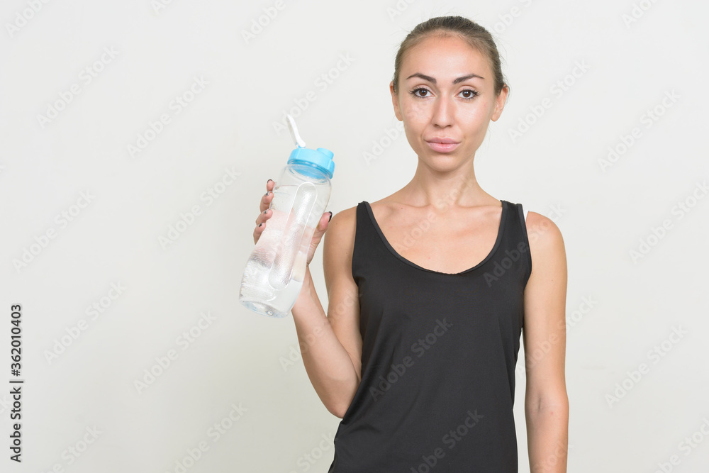 Portrait of young woman holding water bottle ready for gym Portrait of young woman holding water bottle ready for gym