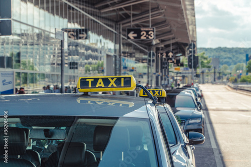 A german taxi waiting in front of an airport for customers.