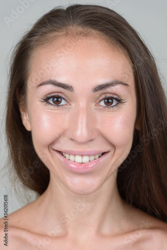 Fotografie Face of happy young shirtless woman with brown hair smiling