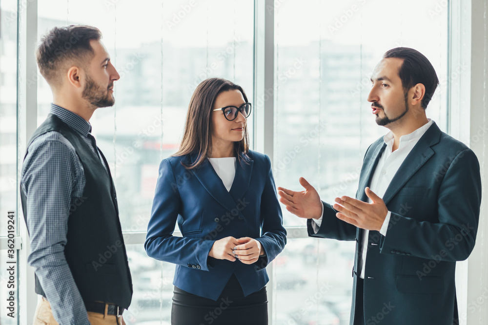 Three successful business people talking in office. Three successful business people talking in office.