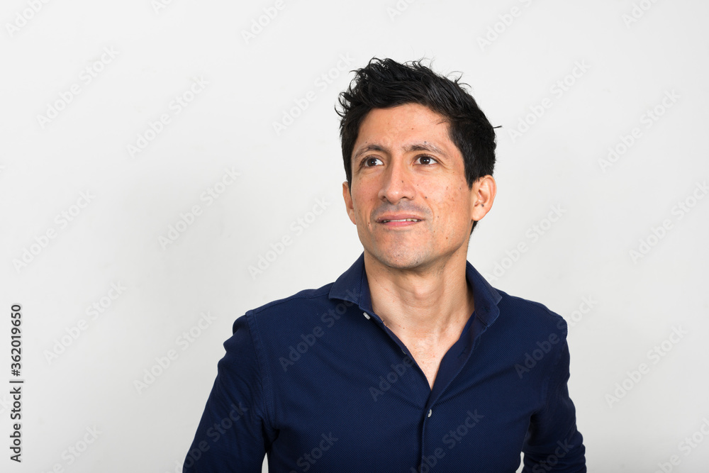 Portrait of happy Hispanic businessman thinking and looking up Portrait of happy Hispanic businessman thinking and looking up