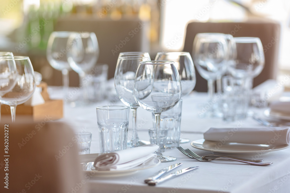 Empty glasses in restaurant background. Table set for an event party or wedding reception. Empty glasses in restaurant background. Table set for an event party or wedding reception.