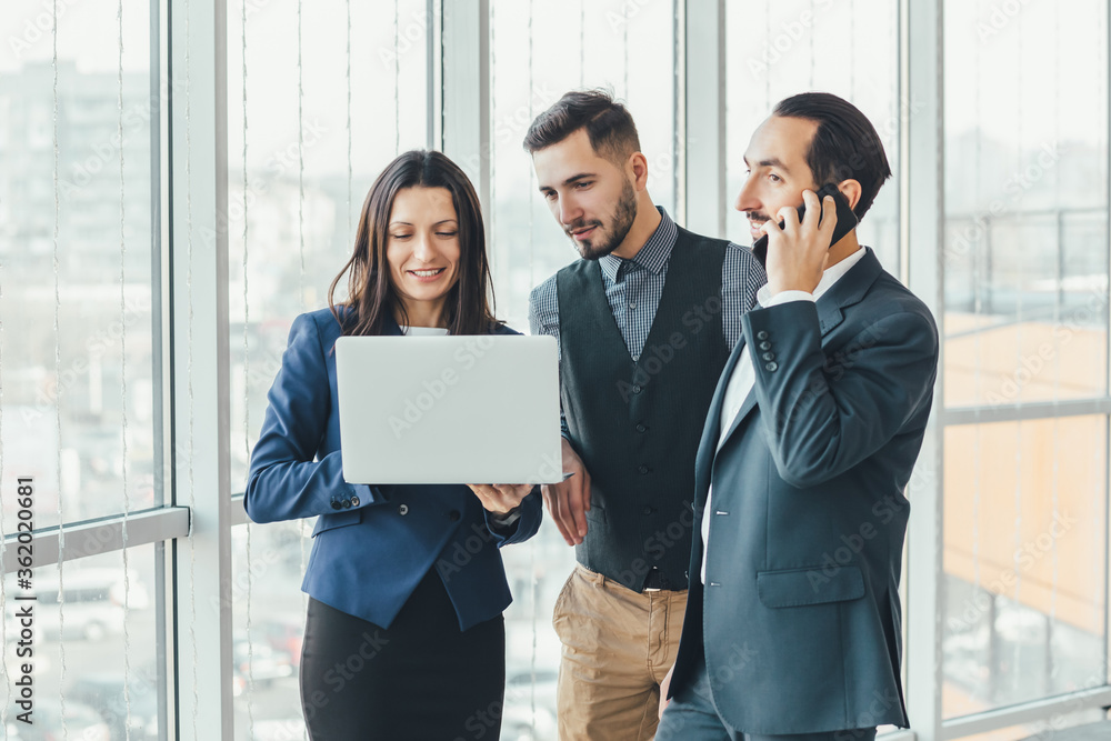 Two businessmen and woman analyzing investment charts and market perspectives, using laptop. Two businessmen and woman analyzing investment charts and market perspectives, using laptop.