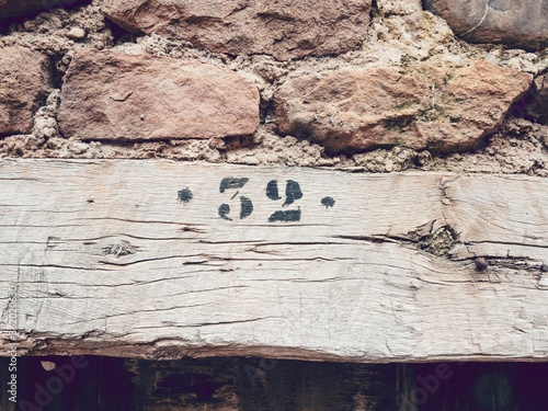 Closeup shot of the number 32 on a wooden surface against a concrete wall photo