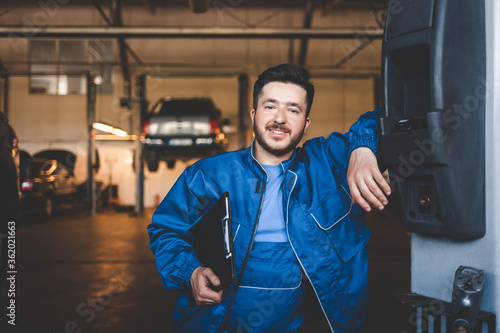 Portrait of a positive car mechanic in a garage