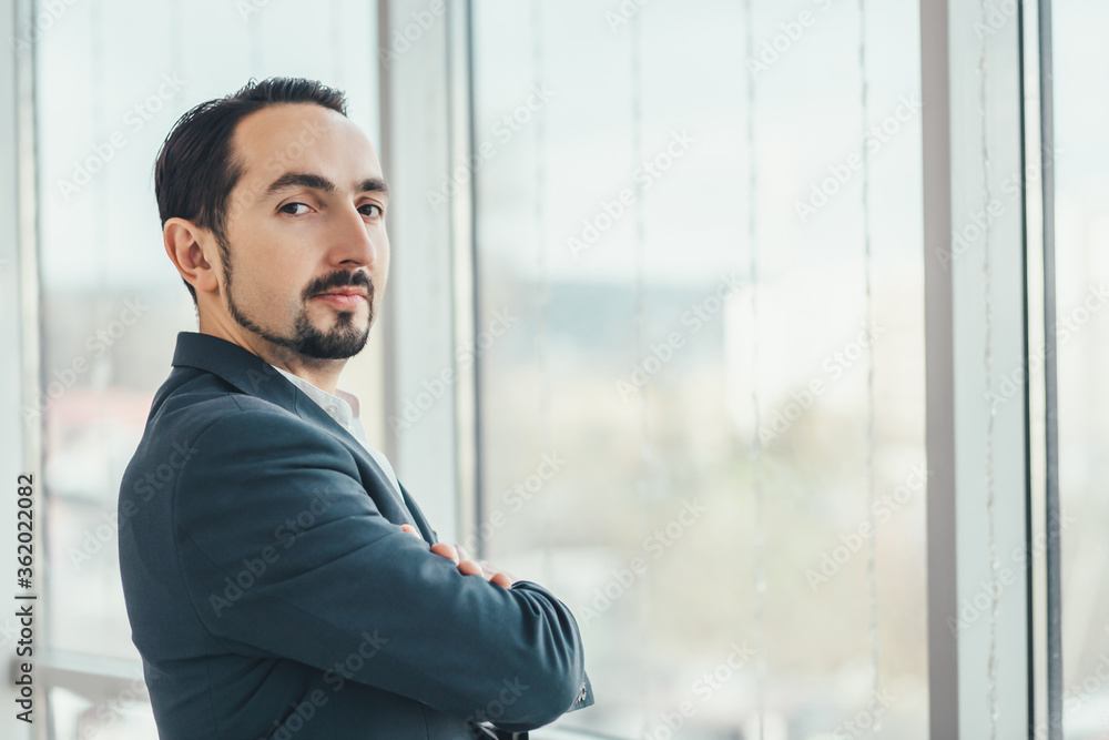 Close up of confident young businessman standing with his hands folded, looking at the camera, ready to hard work day. Close up of confident young businessman standing with his hands folded, looking at the camera, ready to hard work day.