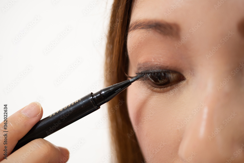 Obraz premium アイラインをまつ毛の下から書く女性