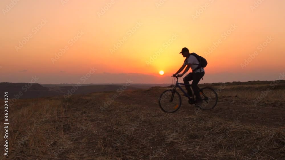 Man Riding Bicycle During Sunset, Outdoors Activity, Sport ,Summer Field - slow motion Man Riding Bicycle During Sunset, Outdoors Activity, Sport ,Summer Field - slow motion
