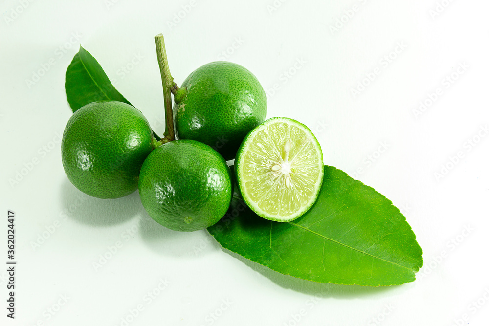 Thai lemons are placed in front of the fruit cluster and separated from a white background.