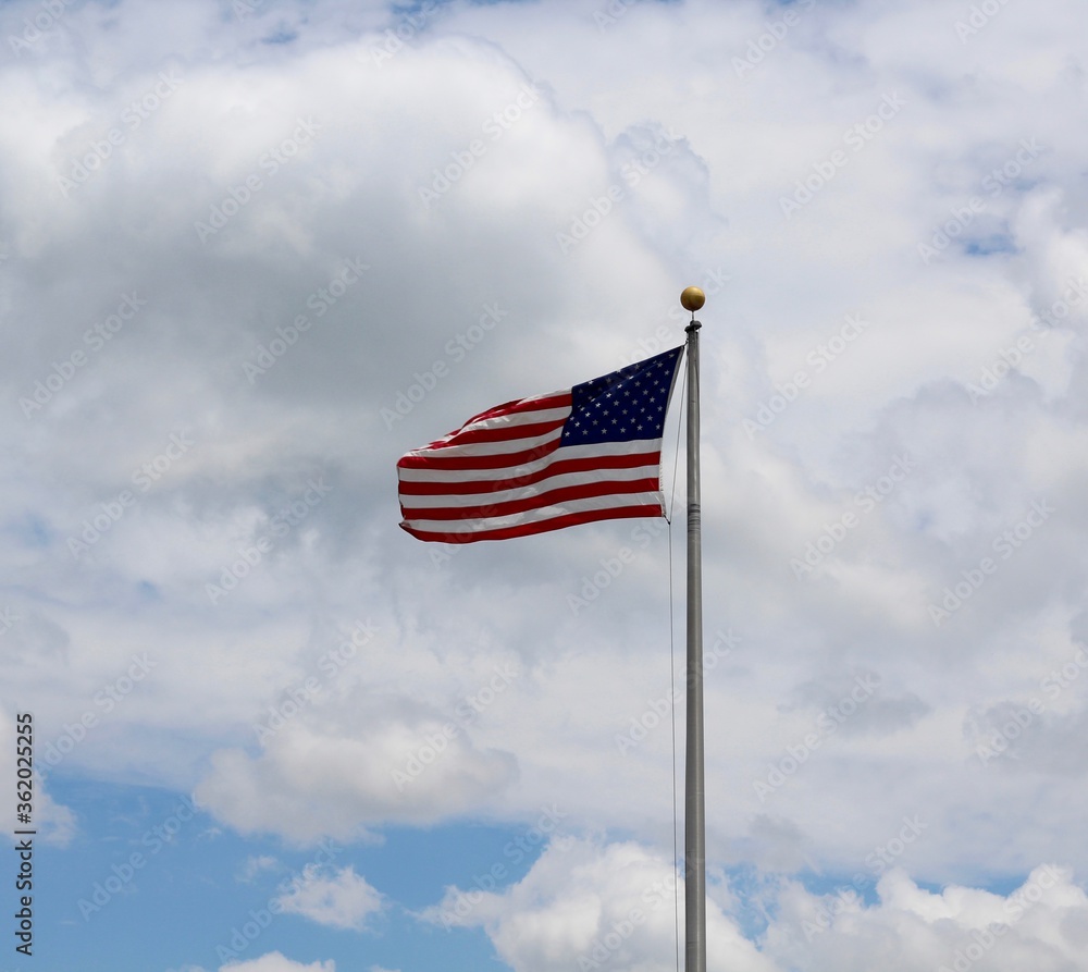 The american flag with the white clouds backdrop.