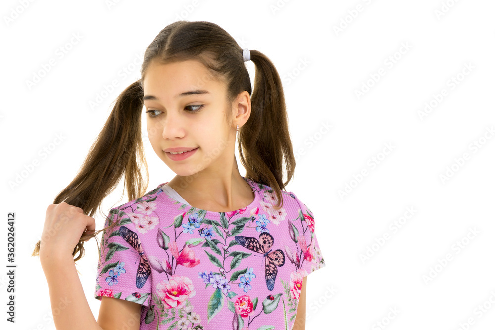 A little girl fixes her hair.The concept of style and fashion, happy people. A little girl fixes her hair.The concept of style and fashion, happy people.