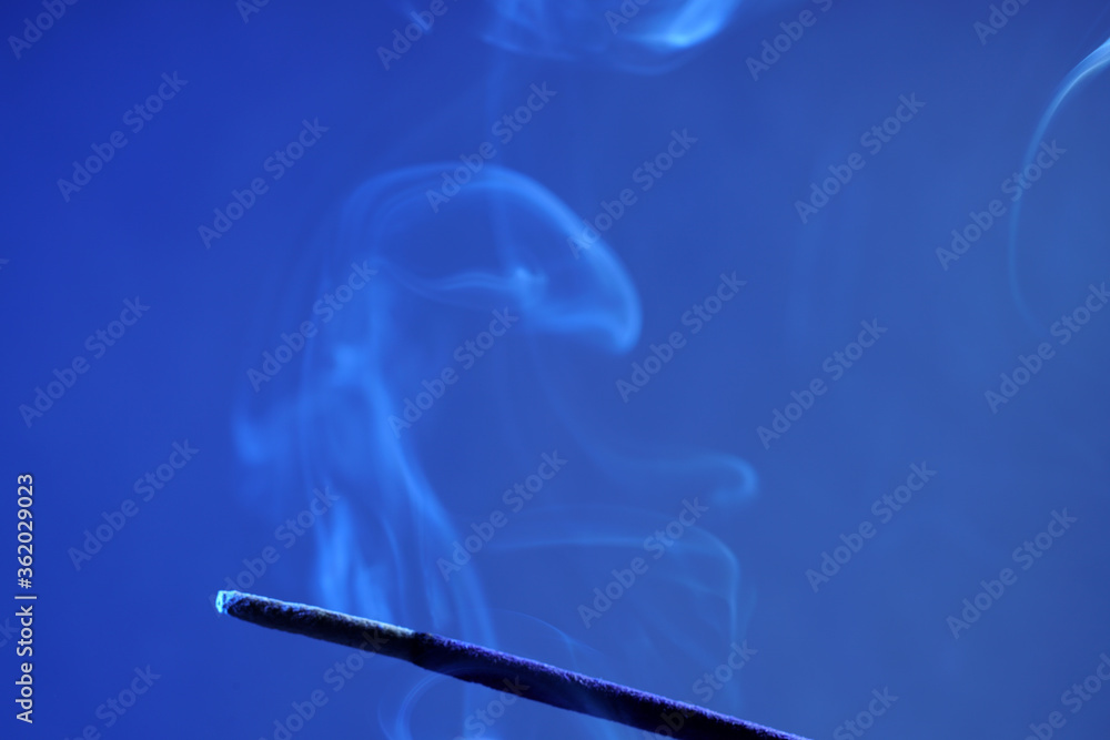 Multi colored smoke from an incense stick with color foils Photographed in front of the flash in the studio Multi colored smoke from an incense stick with color foils Photographed in front of the flash in the studio