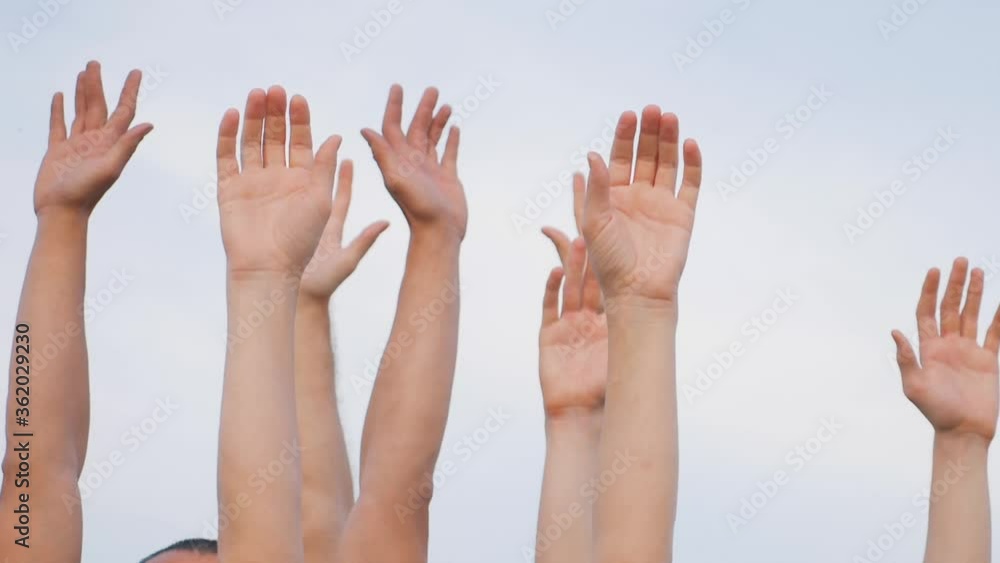 Teamwork. A group of people against the sky raises their hands up. The concept of voluntary voting, expression of consent, support for democracy. Teamwork. A group of people against the sky raises their hands up. The concept of voluntary voting, expression of consent, support for democracy.