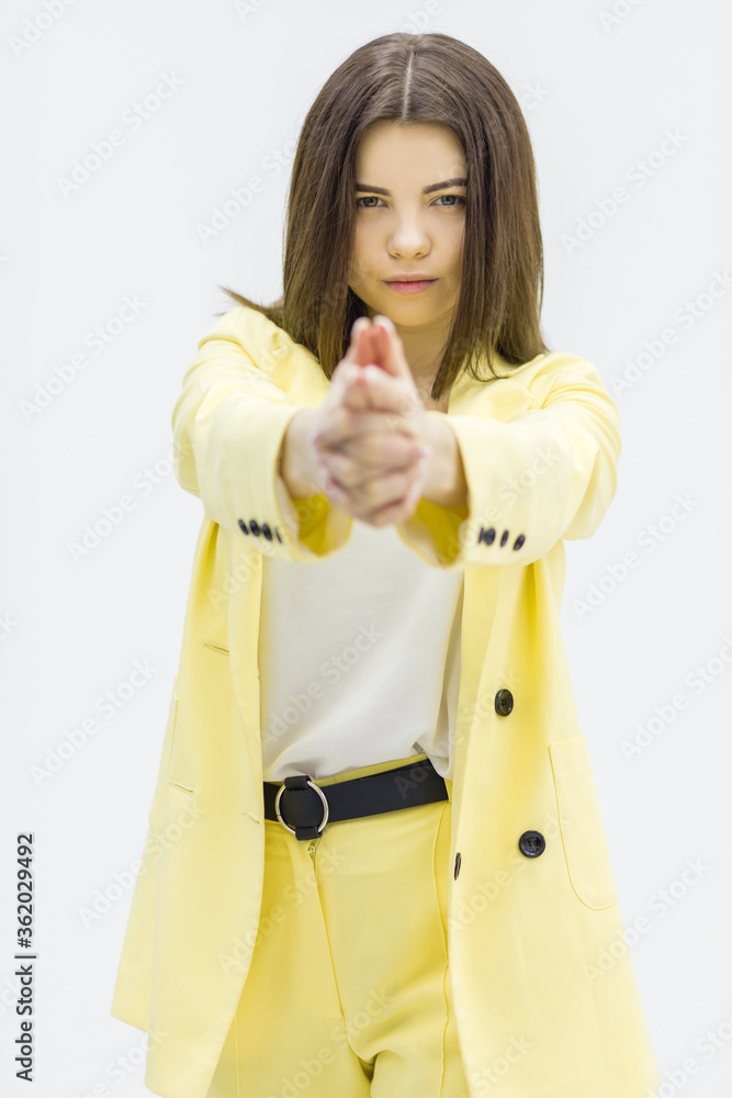 Young woman showing shooting gesture standing on white background. Young woman showing shooting gesture standing on white background.