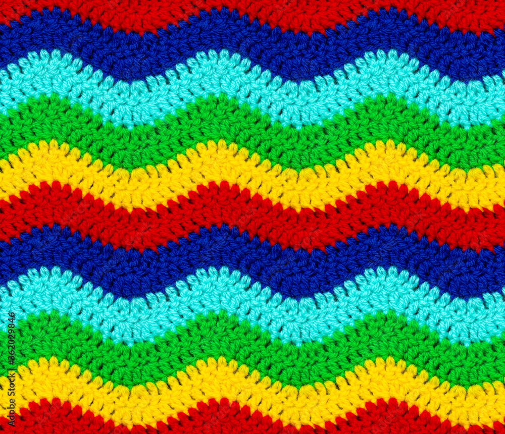 Seamless knitted texture. The zigzag pattern is crocheted with multi-colored threads. Acrylic baby yarn.