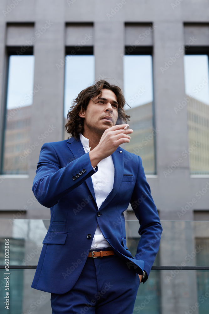 Portrait of handsome young man smoking a cigarette looking concerned and worried Portrait of handsome young man smoking a cigarette looking concerned and worried