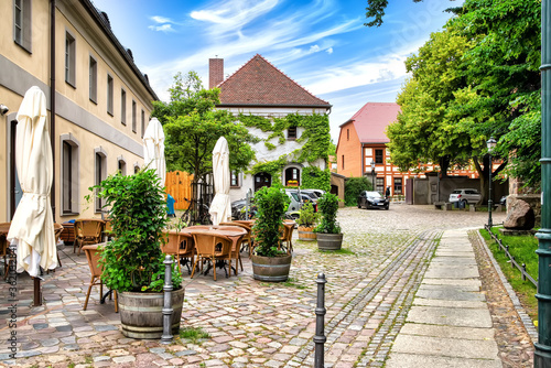 Idyllic street with restaurant, half-timbered house and with ivy green house in the old town of Bernau near Berlin, Germany photo