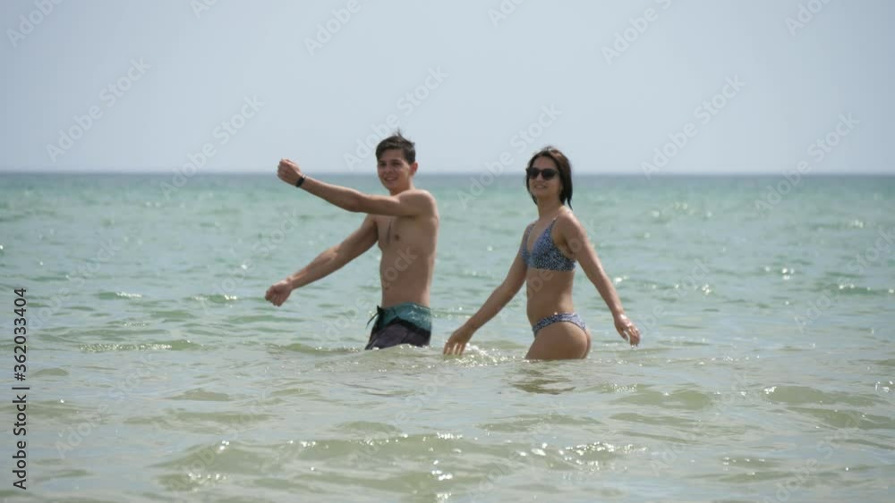 Lovely couple playing and dancing in the Black Sea waves on sunny day in slo-mo Lovely couple playing and dancing in the Black Sea waves on sunny day in slo-mo