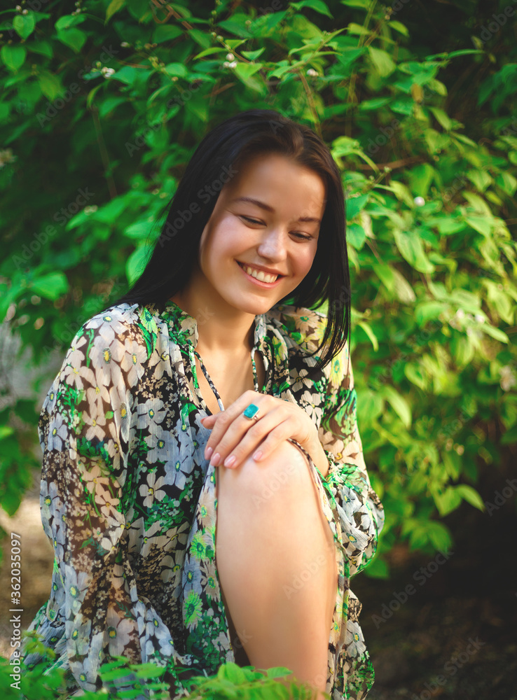 portrait of a beautiful smiling brunette on a background of greenery portrait of a beautiful smiling brunette on a background of greenery