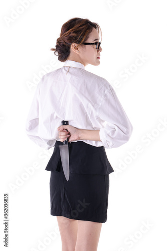 Young Asian business female with knife behind her back , isolated on white background.