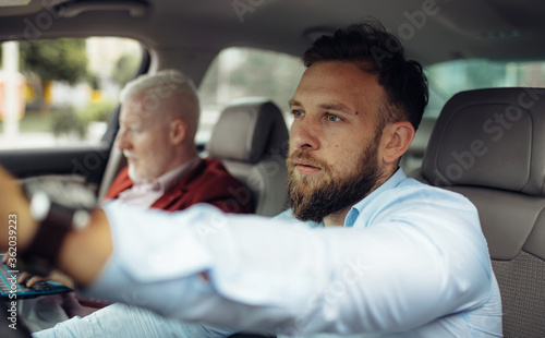 Young businessman driving car.  Two businessman going on a business trip.